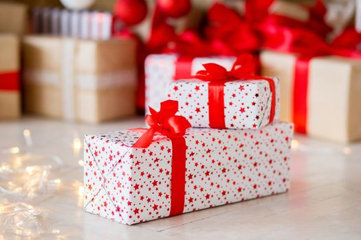 The gift in red packing lies on a floor against the background of other gifts