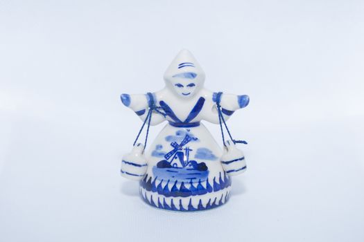 Delft Blue Figurine of girl carrying bells. Souvenier from Holland/Netherlands on isolated white background.