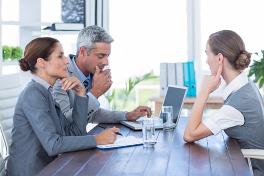 Business people interviewing young businesswoman in office