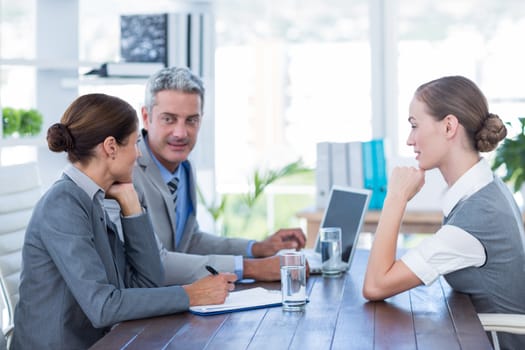 Business people interviewing young businesswoman in office