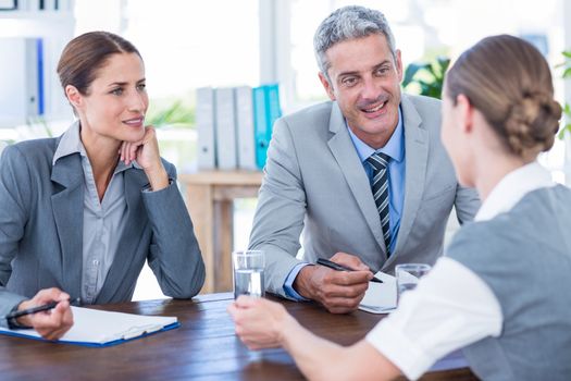 Business people interviewing young businesswoman in office