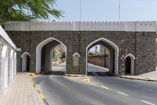 The street into Old Town Muscat, Oman with gates and tunnel in and through the mountains.