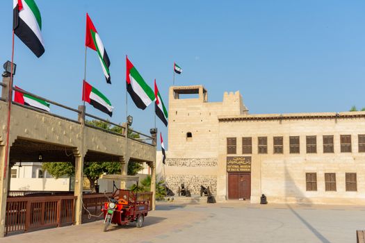 Entrance of the Ras al Khaimah Museum in the morning sun with flags blowing.