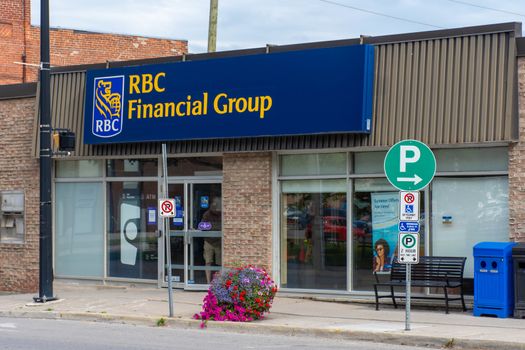 "Brighton, Ontario/Canada - 07/22/2019: Royal Bank of Canada storefront sign in a Downtown rural sreet of small town Canadian city of Brighton near Pesquile Lake Provincial Park in the summer cloudy and sunny day."