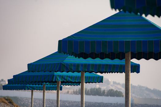 Blue sun umbrellas at the beach on a sunny day.