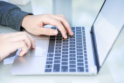 Woman working at home office using laptop searching web, browsing information ,Hand on keyboard close up