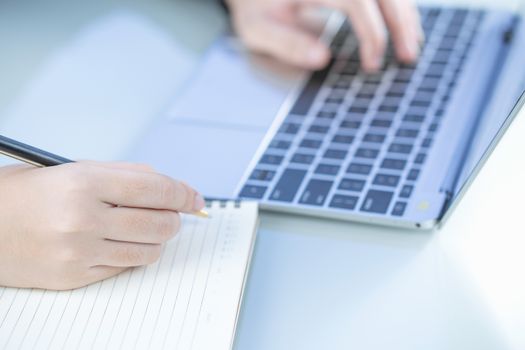 Woman working at home office using laptop searching web, browsing information ,Hand on keyboard close up