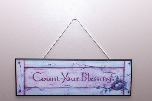 Count your blessings sign hangs on the wall in a home to remember thankfulness and remembering blessings in life.