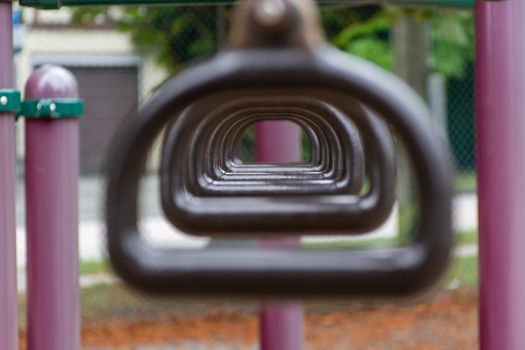 Empty monkey bars at a playground conecept looking through rings at the goals ahead and holding on strong preventing falling and maintaining balance. Concept.
