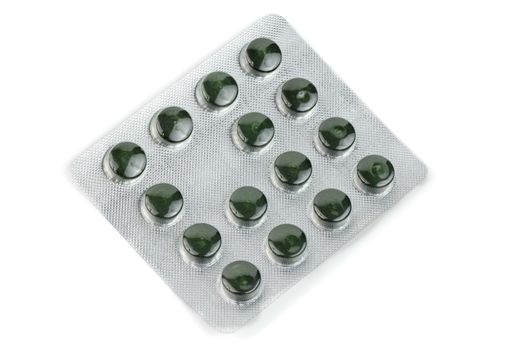 blister pack of green spirulina pills isolated on white background.