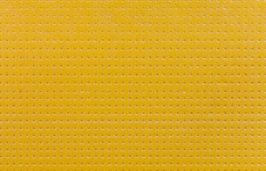 texture and background of sheet of hard yellow styrofoam with punching pattern