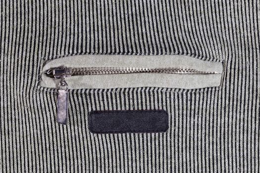 abstract vertical striped texture of flat fabric surface with zip locking chest pocket, and black blank label.