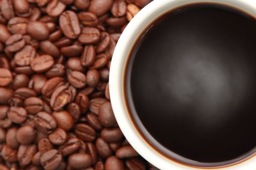 cup of hot coffee with coffee beans in the background