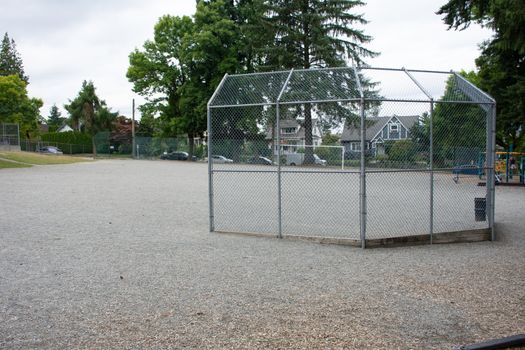 Baseball or softball diamond through a fence in  park in a small town Canadian city of New Westminster, British Columbia, Canada.