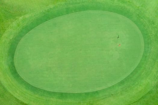 top view of golf pole on the green in a golf course with blank copyspace