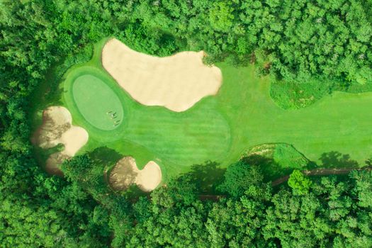 Aerial view of golf course with golfers putting the golf ball on a green