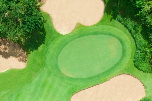 Aerial view of golf course with green fairway and bunker