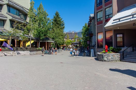 "Whistler, British Columbia/Canada - 08/07/2019: Whistler village streets during the summer looking at the walkway, street, shops and tourists enjoying this Olympic world class destination."