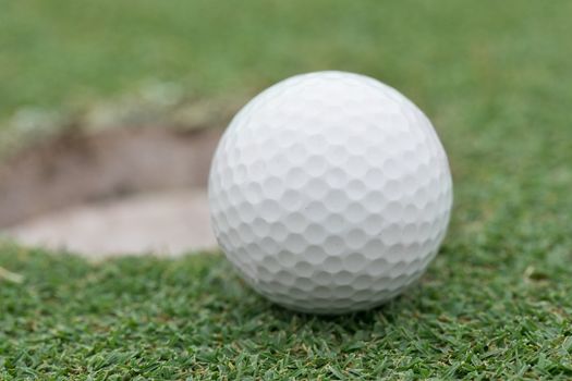 close-up on a golf ball on lip of cup