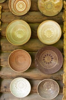 Collecton of empty ceramic bowls on rustic wooden background, vertical