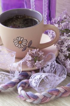 Branches and flowers of lilac with purple petals. Cup with coffee, cocoa, spring breakfast. Vintage, vertical image