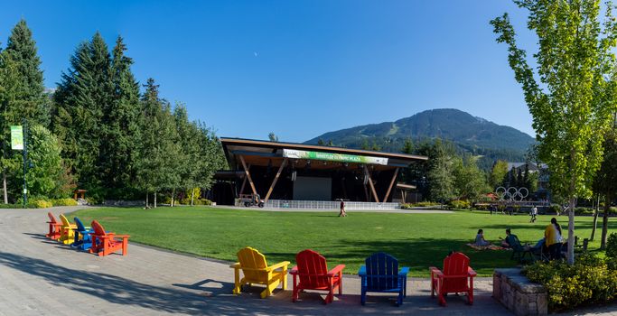 "Whistler, British Columbia/Canada - 8/7/2019: Whistler Olympics Village from 2010 Winter Games. Open Square in summer looking at mountain range and stage."