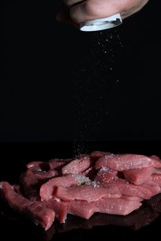 Hand pepper raw pieces of meat. Cooking at home, in the restaurant. Ingredients for the recipe. menu, chef