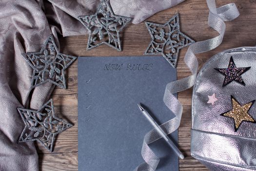 Words and patterns on gray paper. New year, new rules. Motivation, plan, schedule, task, new life. Christmas, holiday. Snowflakes and Christmas toys. The silver background.