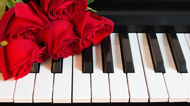 Bouquet of red roses on the piano. Flowers on a musical instrument. Birthday, March 8, international women's day, February 14, Valentine's day, mother's day, flower day. Card, gift, romance, date love
