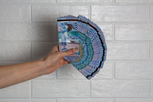 The hand holds a lot of tenge. Kazakhstan, KZ, KZT. Banknote, paper currency, Bank. Salary, credit, savings, pay and spend. Business and Economics.