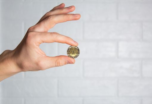 Hold the tenge coin in your hand. Close up. New Kazakhstan coin 200 tenge. Money, Bank, save, spend.
