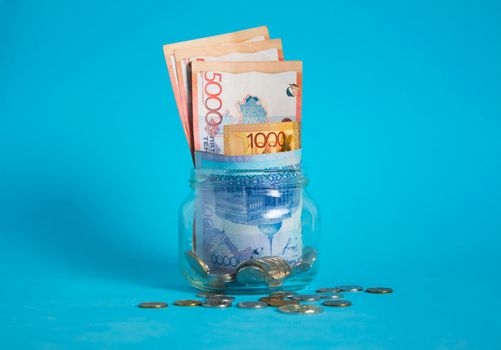 Tenge in a glass jar. Kazakhstan, KZ, KZT. Banknote, paper currency, coins, Bank. Salary, credit, savings, pay and spend. Business and Economics.