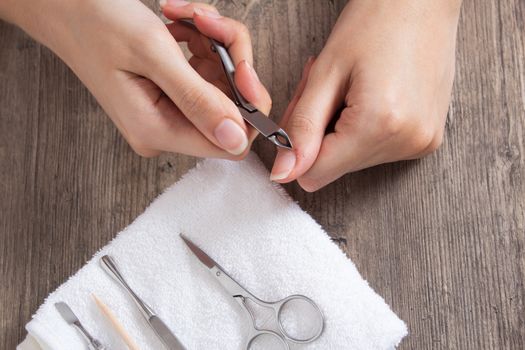 A woman does a manicure at home. Manicure tools. Edged manicure. Cut, wound on the finger, blood. Dangerous manicure. Home care, Spa, beauty.