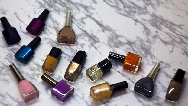 Scattered nail Polish in the beauty salon. The choice of color nail Polish for manicure or pedicure. gel Polish for manicure on a marble table.