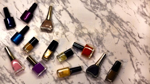 Scattered nail Polish in the beauty salon. The choice of color nail Polish for manicure or pedicure. gel Polish for manicure on a marble table.