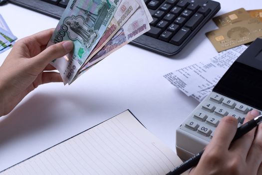 The issue of wages in Russia. Accountant cashier counts the money in rubles and fills the reports and statements. Office worker in the workplace.