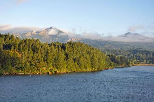 Beautiful Columbia River flowing through Oregon with mountains and clouds in background