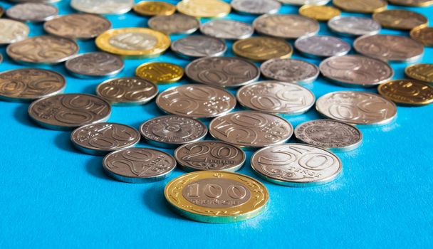 Tenge on a blue background with coins. Tenge coins of Kazakhstan