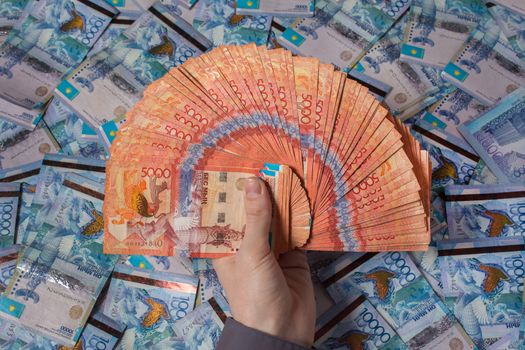 Hands holding Kazakhstani tenge money. Paper banknotes tenge KZT. Tenge is the national currency of Kazakhstan. bank of Kazakhstan