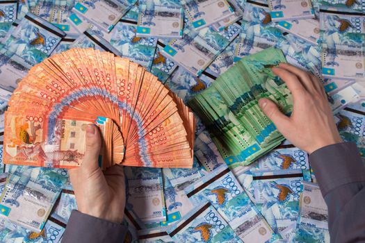 Hands holding Kazakhstani tenge money. Paper banknotes tenge KZT. Tenge is the national currency of Kazakhstan. bank of Kazakhstan