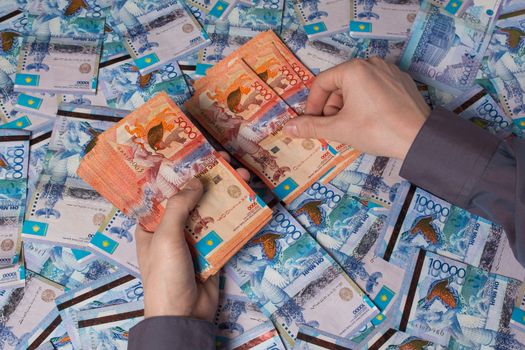 Hands count Kazakhstan money tenge. Paper banknotes tenge KZT. Tenge is the national currency of Kazakhstan. bank of Kazakhstan