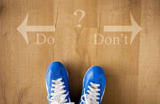 DO versus DON`T written with arrows on wooden floor, dilemmas concept.