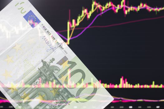 euro, EUR in front of a laptop monitor with a price chart.Forex and trading.A trader trades stocks,bonds and securities or currencies on the Forex market or stock exchange for euro