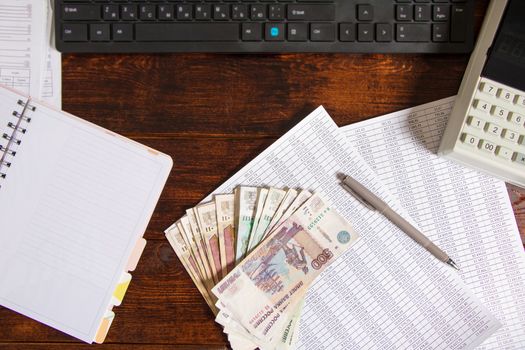 Russian rubles are on the table next to the computer, Notepad and documents in the office or Bank.