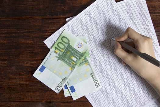 Money Euro are on the desktop in the office next to the computer, phone, documents and cash register.Obligation to pay wages and debts in the company.Work in the office with finances in Europe