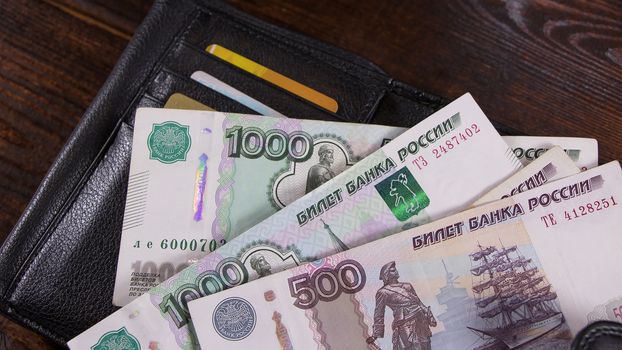 Lot with Russian rubles is on the wallet with credit cards.Paper banknotes Russian Rubles.Rubles is the national currency of Russia.bank of Russia.A thousand rubles close-up.Fall or rise of the ruble