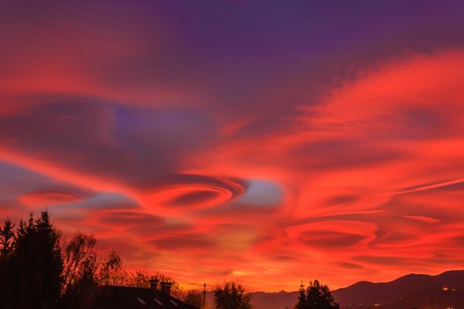 the lenticular clouds are due to the diffusion of water vapor,the red rays of the sun crossing the crystalline atmosphere
