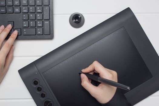Graphic designer working on digital tablet. The hand draws on a graphics tablet. Freelance, designer, Illustrator. Technology, remote work, outsourcing.Project, concept, close-up, creativity. Glove and pen for a graphic tablet. 