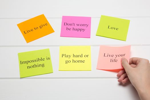 The hand lays out motivational cards. Color sheets with quotes. Visualization Board, self-discipline, development, training. Flat lay, top view. plan, strategy, concept, future.