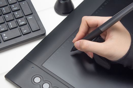 Graphic designer working on digital tablet. The hand draws on a graphics tablet. Freelance, designer, Illustrator. Technology, remote work, outsourcing. Glove and pen for a graphic tablet. Project